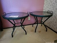 Both matching green metal and glass side tables