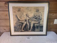 Full view of framed drawing on table against wall