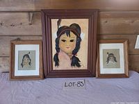 Group shot of three framed artworks on table