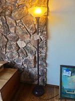 Full view of torchiere lamp showing base, post and illuminated shade