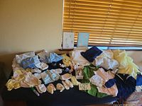 Full layout of all clothing, blankets, booties, shoes and figurines on table