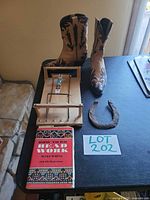 Group shot of all items: boots, bead loom with bracelet, book, horseshoe