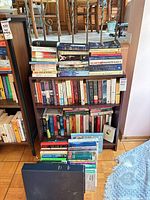 Overall view of shelf and floor stacks of assorted books
