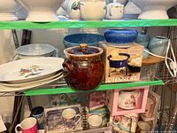 Group on shelving showing platters, bowls and brown crock