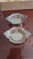 Two pierced sterling nut bowls on table