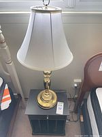 Lamp with shade on top of side table, overall view