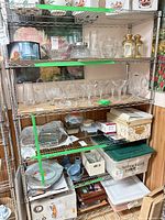 Full view of chrome wire shelving loaded with glassware illustrating five tiers and casters