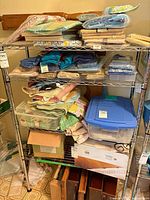 Front view of chrome shelving with linens, tote, bins, boxes and wooden items