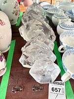 Row of seven clear and frosted glass bear paperweights on table