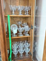 Cabinet top and middle shelves showing multiple coupe glasses