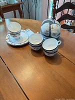Mixed china lot on table showing Coalport and Minton teacups and saucers