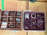 Two trays showing entire assortment of earrings and starfish brooch
