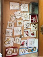 Drawer view showing multiple packaged brooches, hoop earrings, bangles