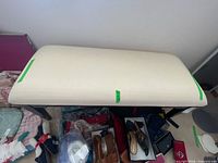 Top view of ivory upholstered bench with brown wood legs visible