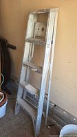 Full view of 5-step aluminum ladder leaning against wall