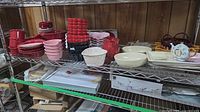 Shelf view of entire assortment: plates, bowls, ramekins, serving pieces and teapot clock