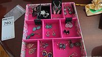 Full tray showing multiple pairs of dangle earrings