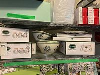 Shelf view showing boxed Portmeirion Botanic Garden spice jar set, mini bowl set, rectangular tray box, two loose bowls and oval divided platter