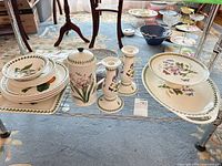 Entire lot on wire shelf showing plates, platter, candlesticks, lidded jar