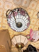 Overall view showing pink floral stained glass dome shade, chain, and secondary cream panel shade