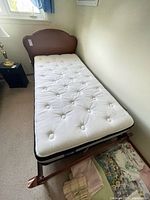 Full view of assembled twin bed showing wood headboard, frame, mattress