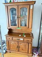 Front view of Vilas two-piece hutch showing glass upper cabinet and buffet base