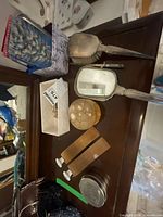 Overall lot showing mirror, brush, boot shapers, tins and trinket box on dresser