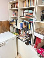 Overall view of white bookshelf filled with books