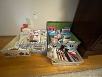 Three boxes/trays filled with socks, pantyhose packages, adhesive bras and small accessories