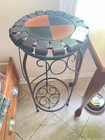 Full view of wrought iron plant stand with wood-inset top