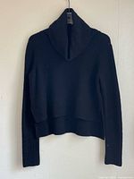 Front view of black sweater on hanger