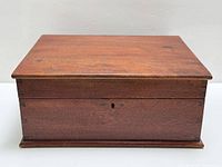 Closed walnut jewelry box front view showing dovetail joints and keyhole
