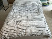 Overall view of duvet with striped cover on bed