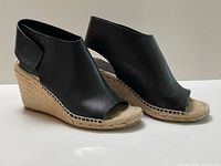 Side view of both sandals showing leather uppers and jute wedge