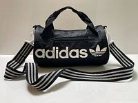 Front view showing adidas wordmark, Trefoil, and striped shoulder strap