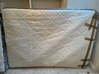 Front view of mattress wrapped in plastic