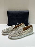 Pair of woven leather sneakers positioned in front of black Fratelli Rossetti ONE dust bag