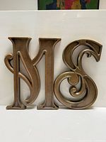 Front view of both gold resin letters M and S