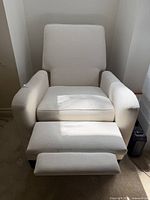 Front view of off-white recliner with footrest extended