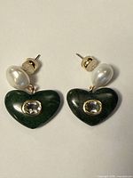 Front view showing both earrings with jade hearts, clear stones and pearl studs
