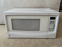 Front view of white GE microwave oven closed