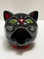 Front view of black cat ashtray showing facial details