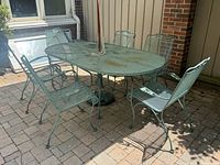 Full view of oval table with six chairs on patio