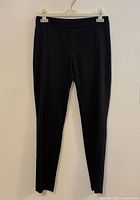 Front view of black trousers hanging