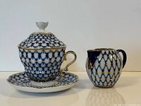 Set showing covered cup on saucer beside creamer