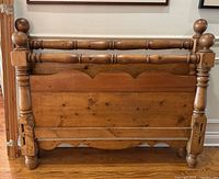 Front view of pine headboard showing turned spindle and ball finials