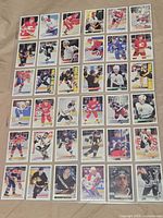 Overhead layout of approximately 30 Premier hockey cards from 1990s showing various teams and players
