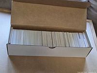 open long storage box filled with stacked trading cards