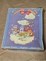 Top of blue Care Bears puzzle box showing artwork and wear