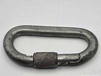Full view of closed carabiner displaying screw-lock sleeve and overall wear